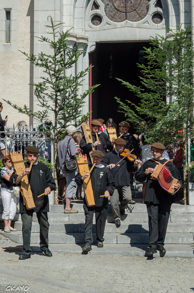 Sortie de la messe avec des cantiques polyphoniques, les musiciens en costumes traditionnels.